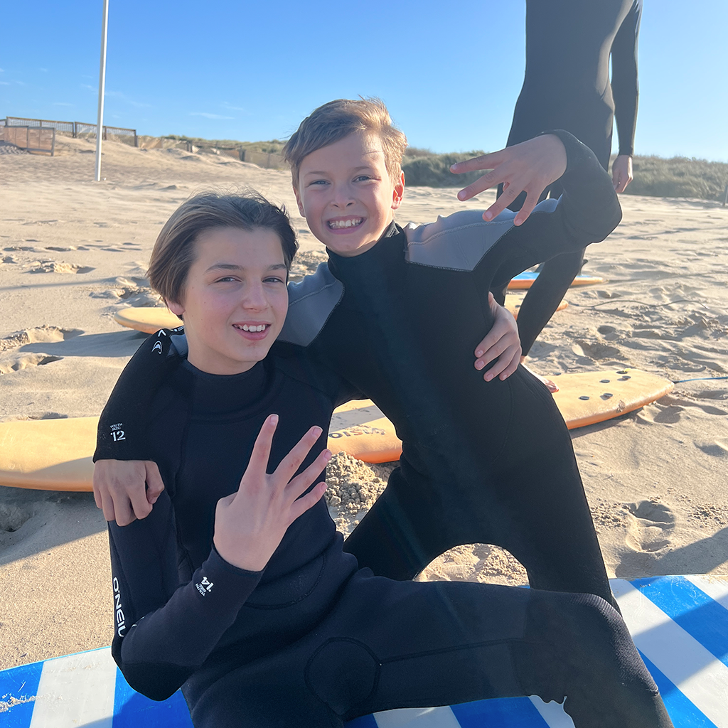 Twee kinderen lachend op het strand.